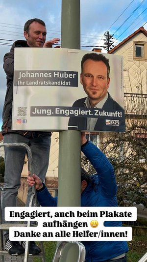 Landratskandidat Johannes Huber hängt Wahlplakate auf.